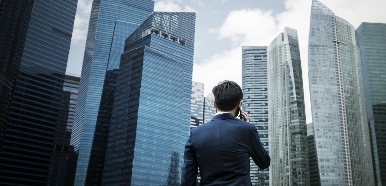 man on cell phone with city skyline in background