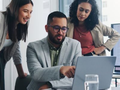 Tre colleghi lavorano ad una presentazione in ufficio