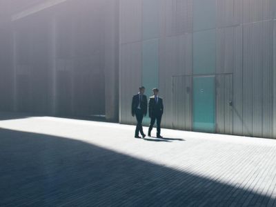 Due colleghi esperti di rischio finanziario si confrontano nel cortile esterno dell'azienda