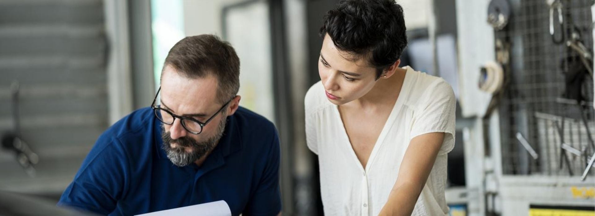 Due lavoratori in un'officina meccanica controllano delle fatture