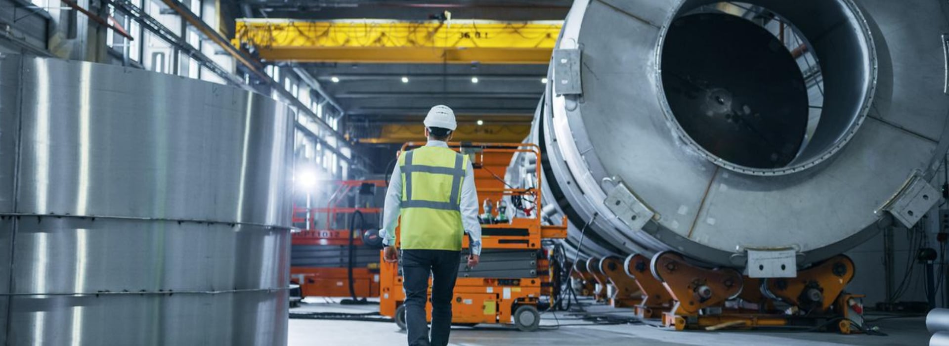 Un operaio di spalle cammina in uno stabilimento del settore metallurgico