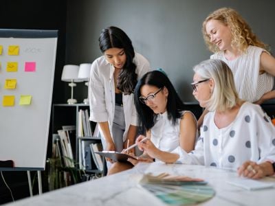 tre donne lavorano insieme in sala riunione