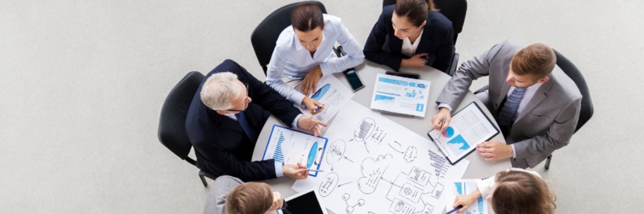 Team di professionisti con schema durante un meeting discutono in ufficio