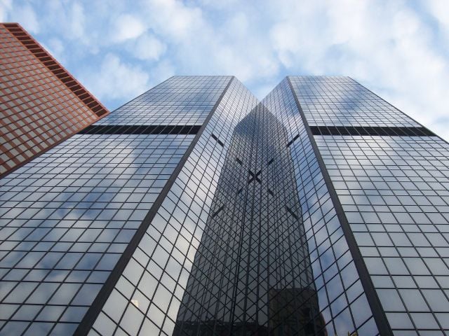 Edifici moderni con facciate in vetro visti dal basso, simbolo di contesto economico internazionale