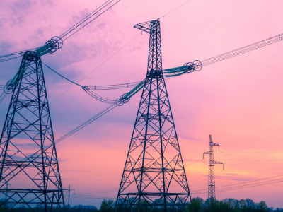 Tralicci elettrici con cielo rosa sullo sfondo