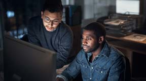 two man in front of the laptom in the office