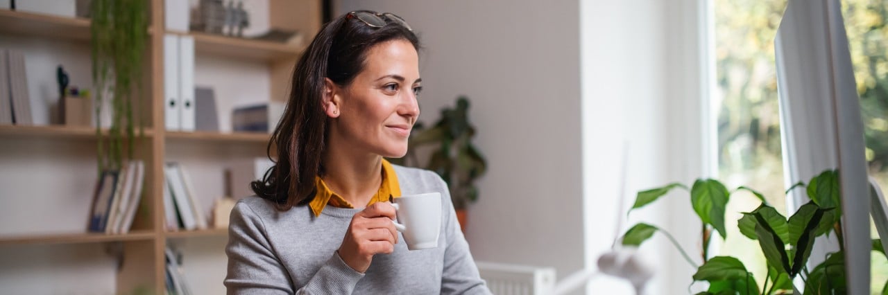 A woman holding a cup of coffee.