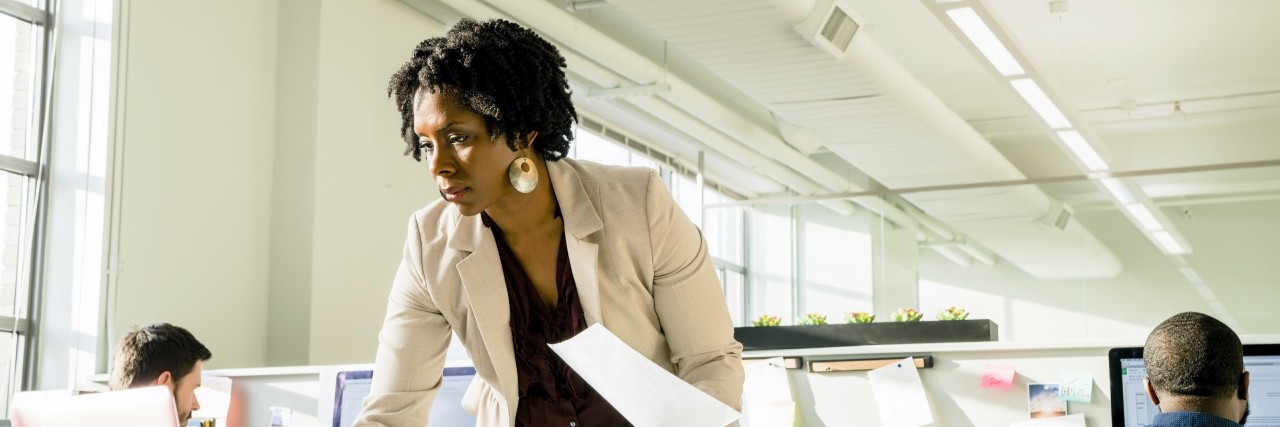 A woman is organizing paper reports.