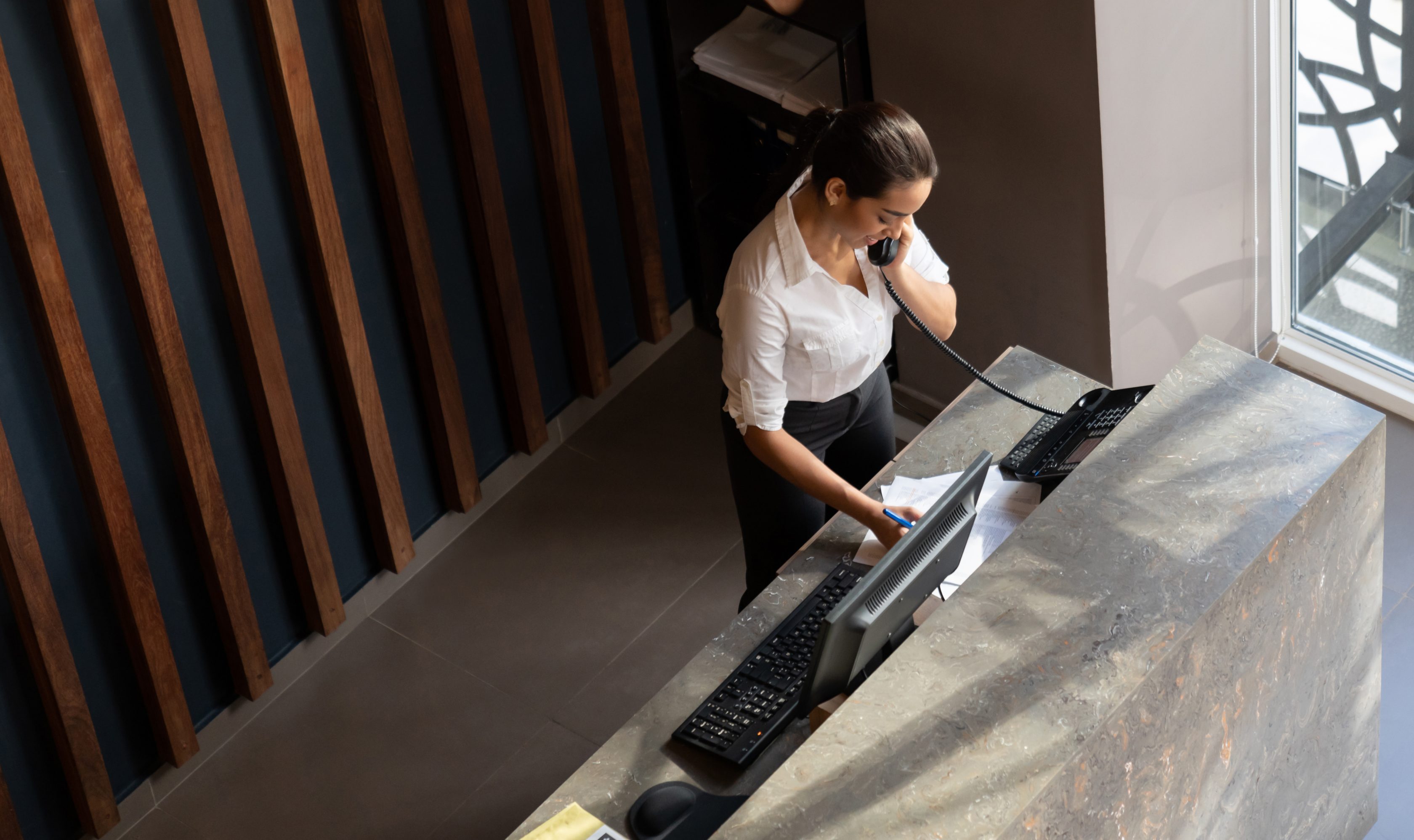 woman standing in office on phone and computer