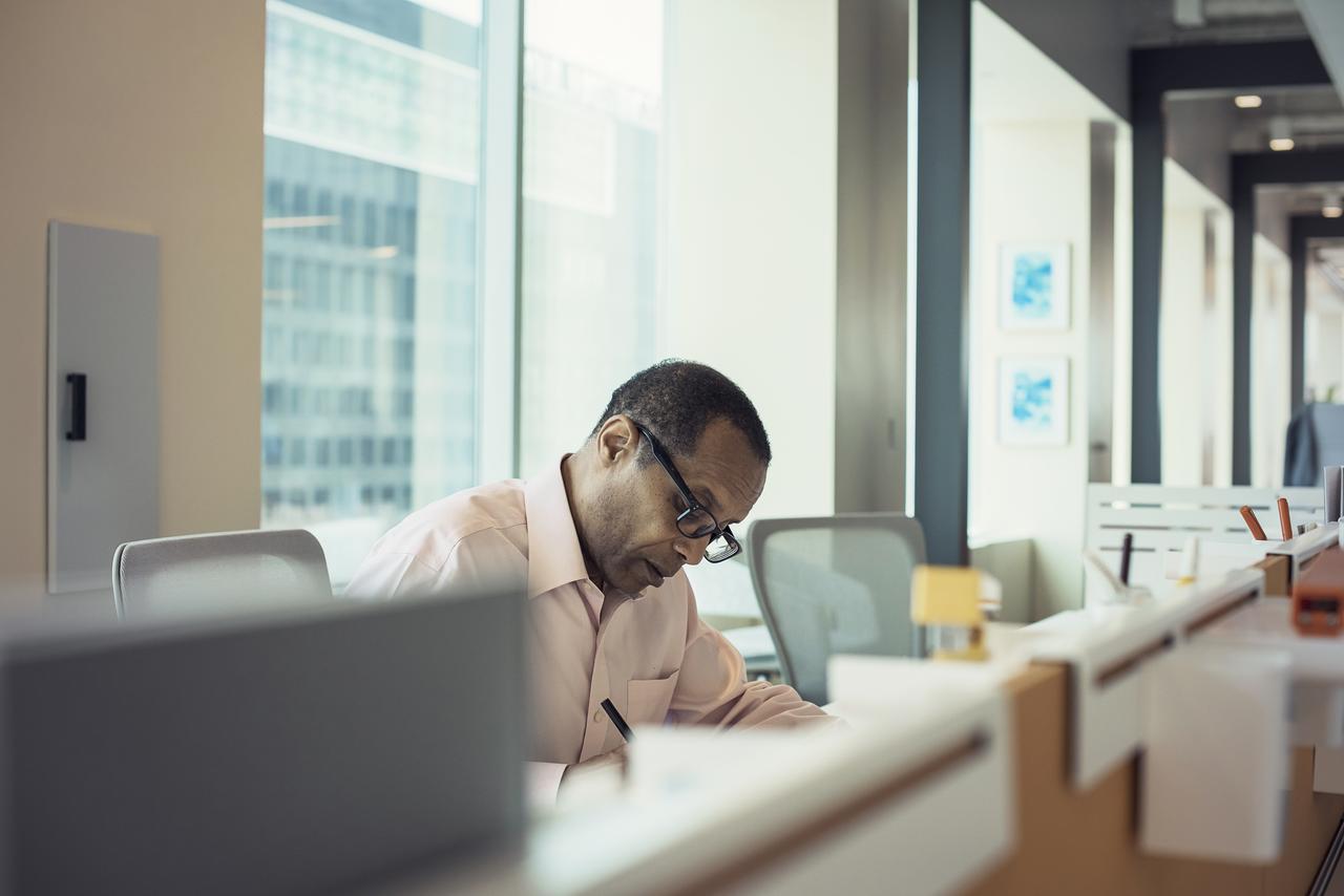 man in office looking down at desk