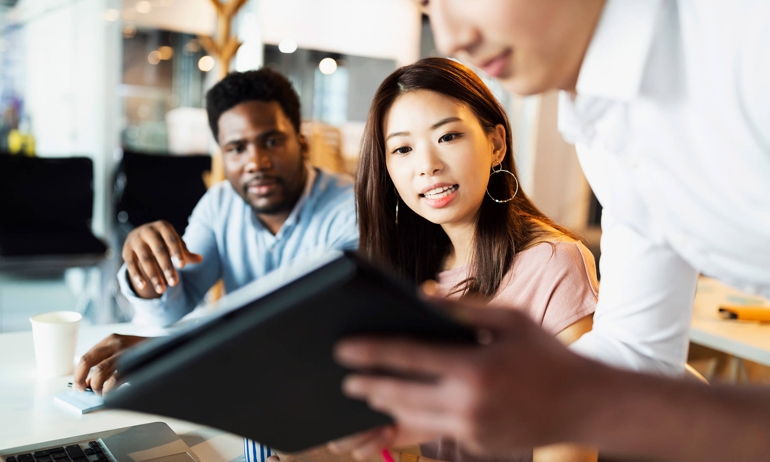 three people looking at tablet