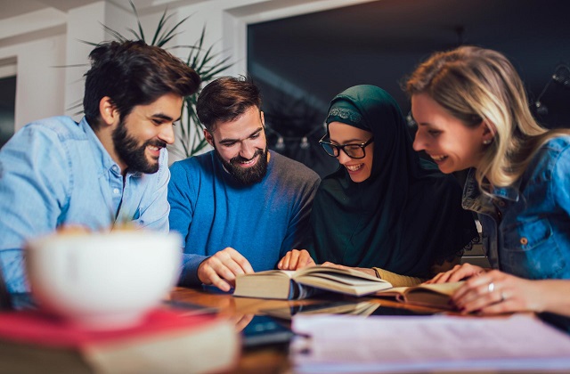 Quattro colleghi consultano un manuale