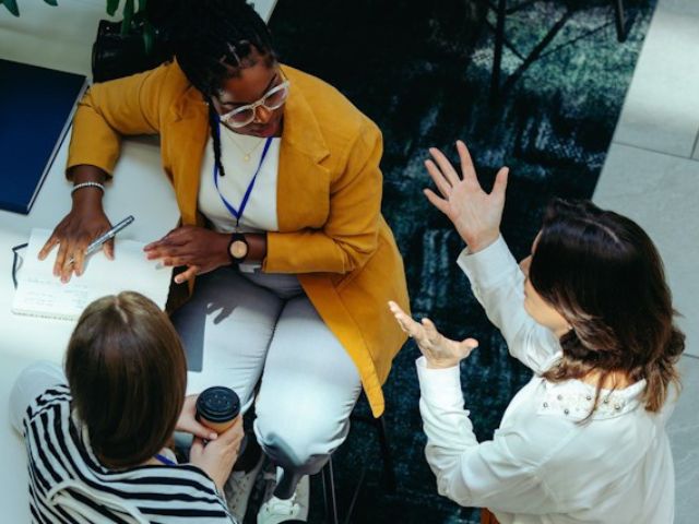 Vista dall'alto di tre manager in ufficio che si confrontano prima di una riunione