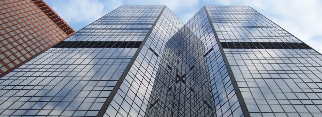 Edifici moderni con facciate in vetro visti dal basso, simbolo di contesto economico internazionale