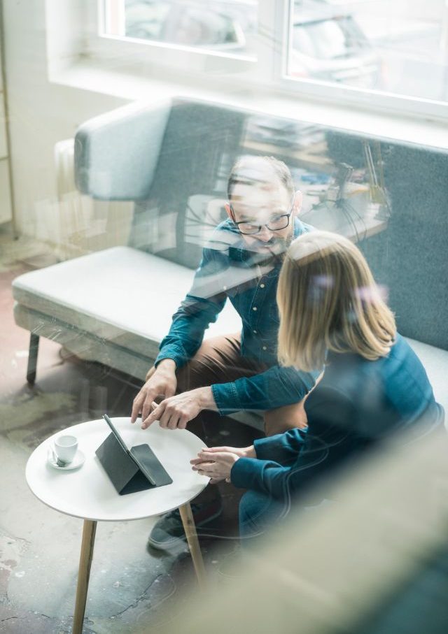 Δύο άτομα σε έναν καναπέ συζητούν για δουλειές