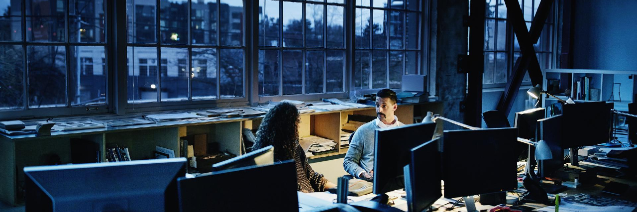 two-people-working-in-office-in-evening-hero