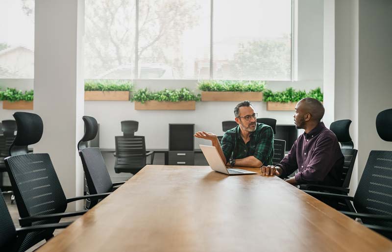 Two man talks in front of the laptop 