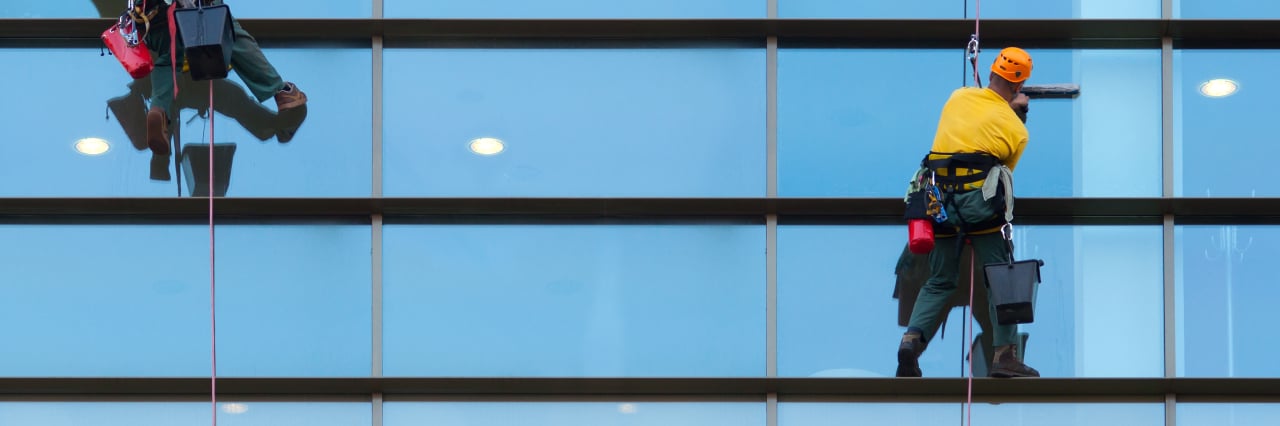 Two people are cleaning window.