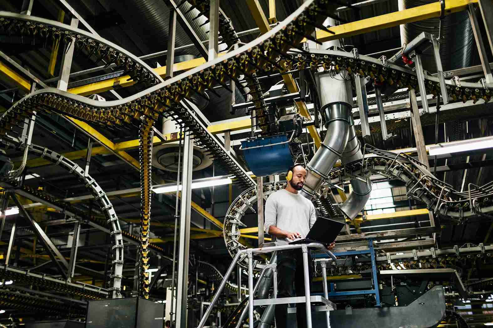 man-using-laptop-in-front-of-a-huge-machine