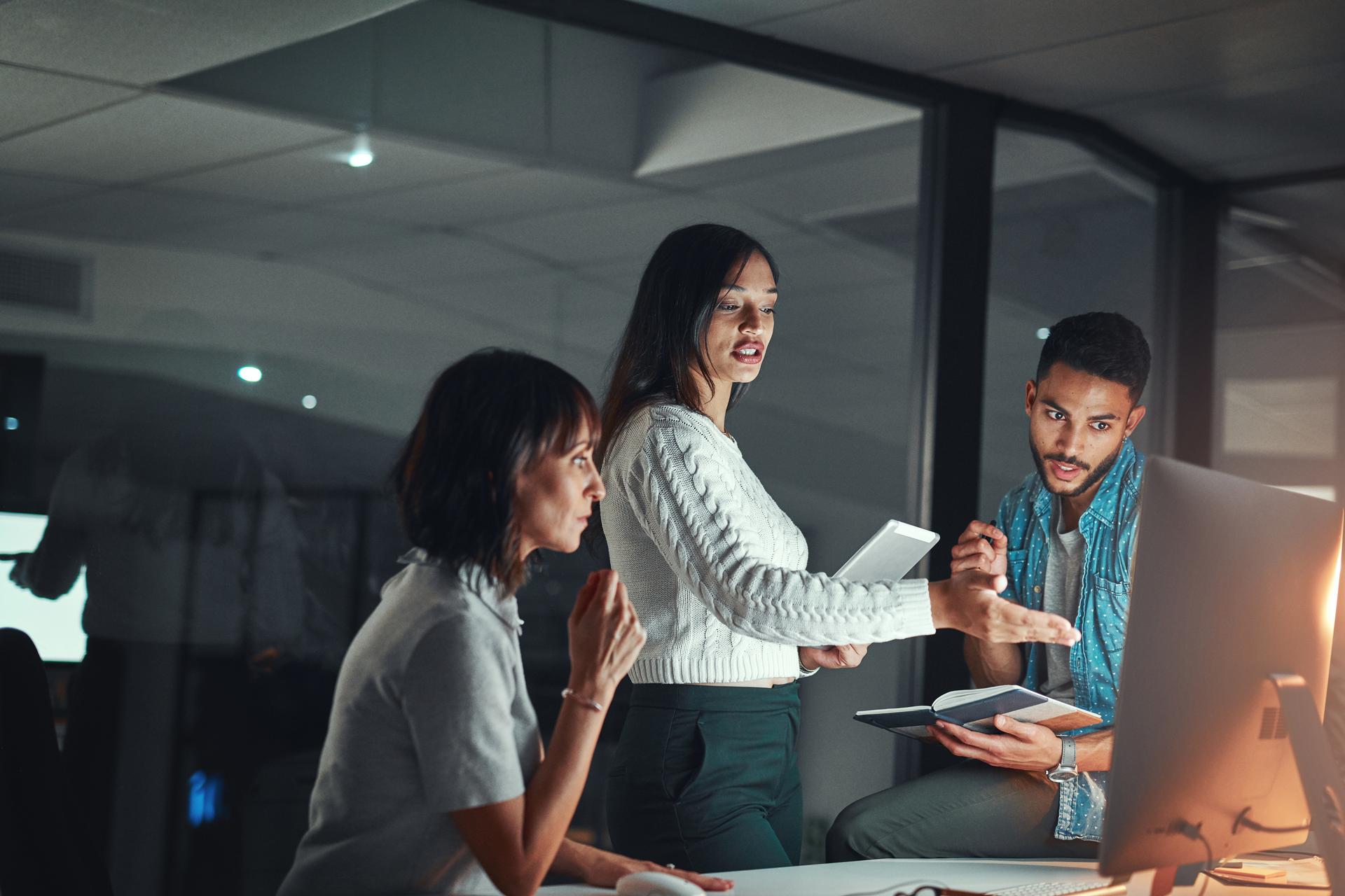 three-people-discuss-facing-computer-screen