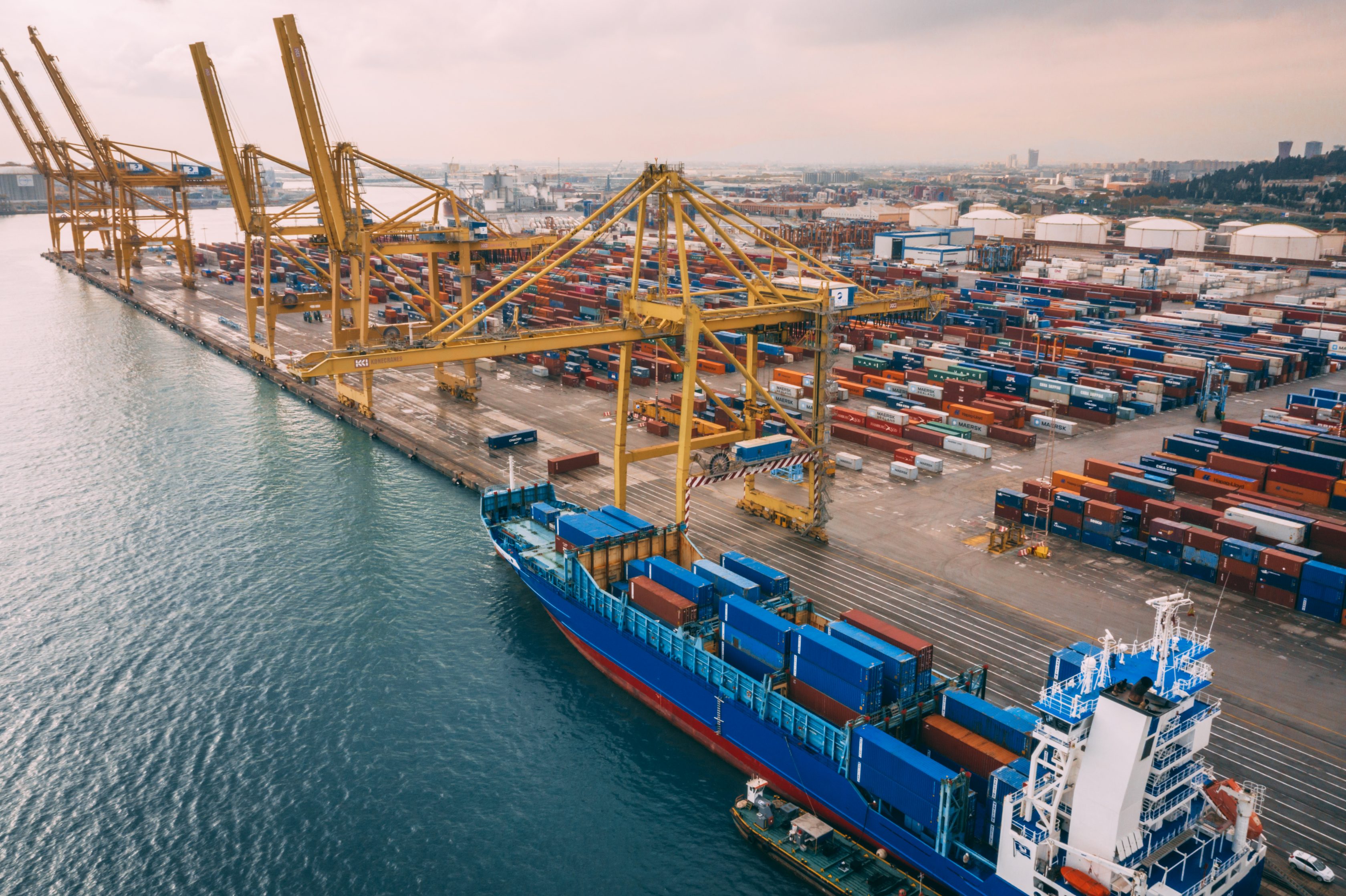 cargo ship docked at port with cranes and cargo containers