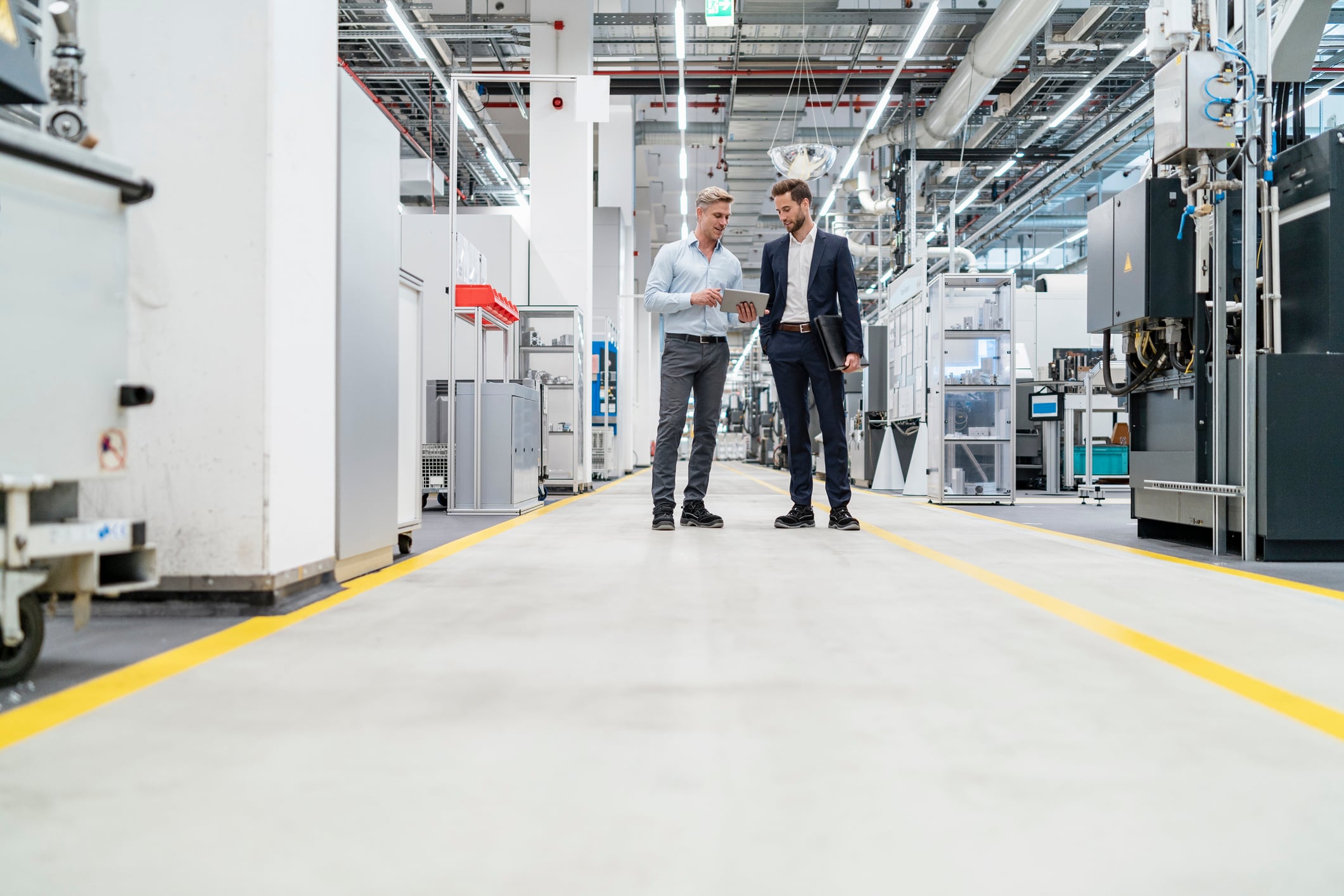 woman standing stoicly with arms crossed with folder in between them
