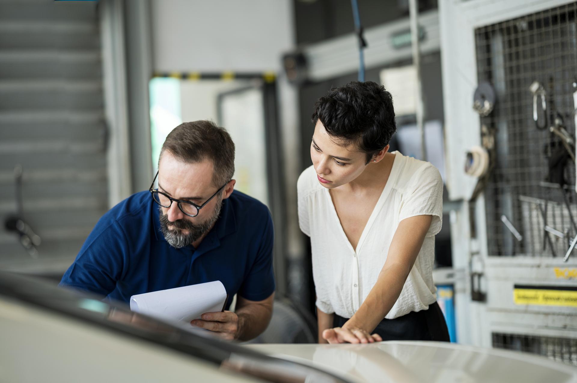 man and woman looking down at table in office