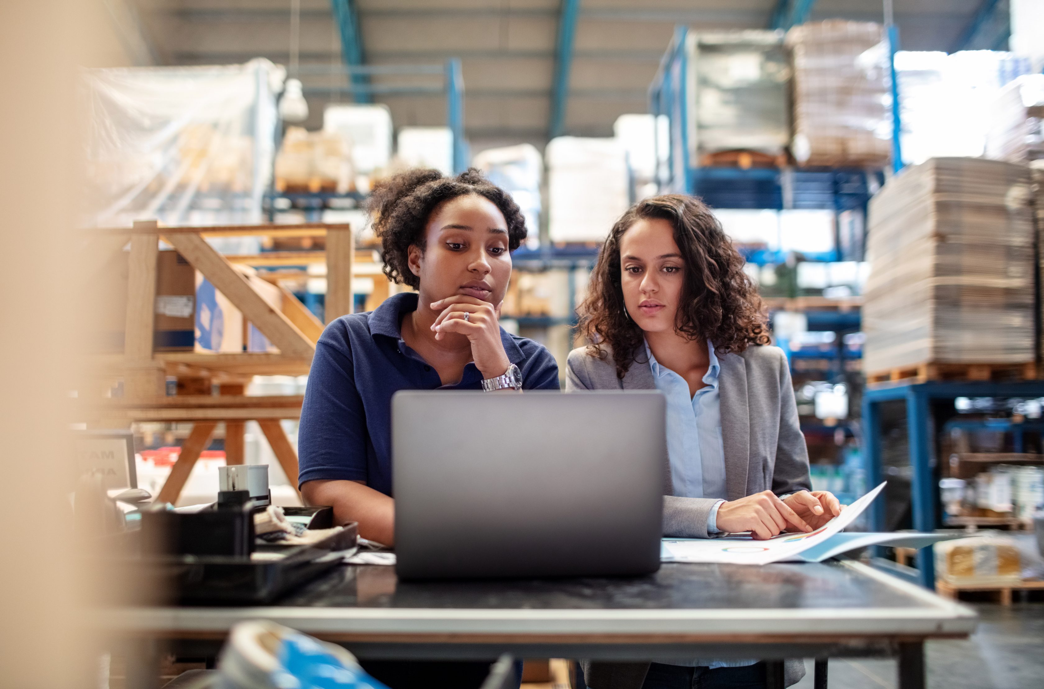 two female workers looking at computer in warehouse setting