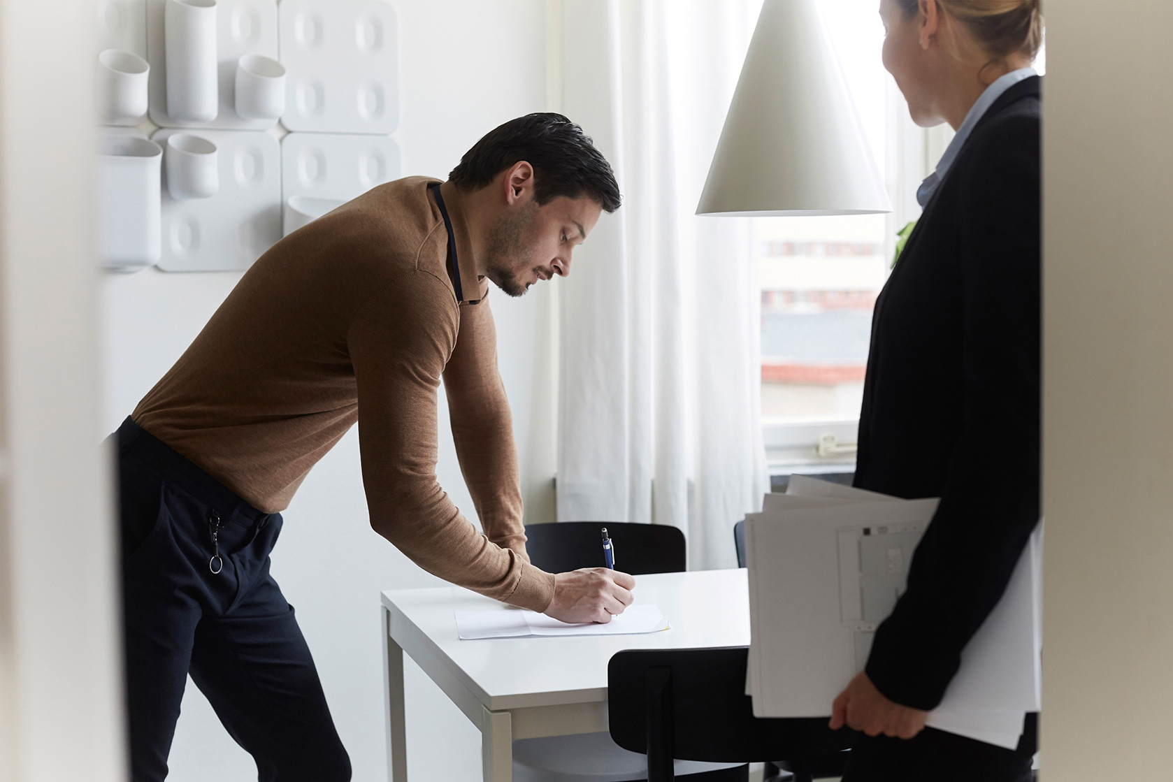 man writing on paper
