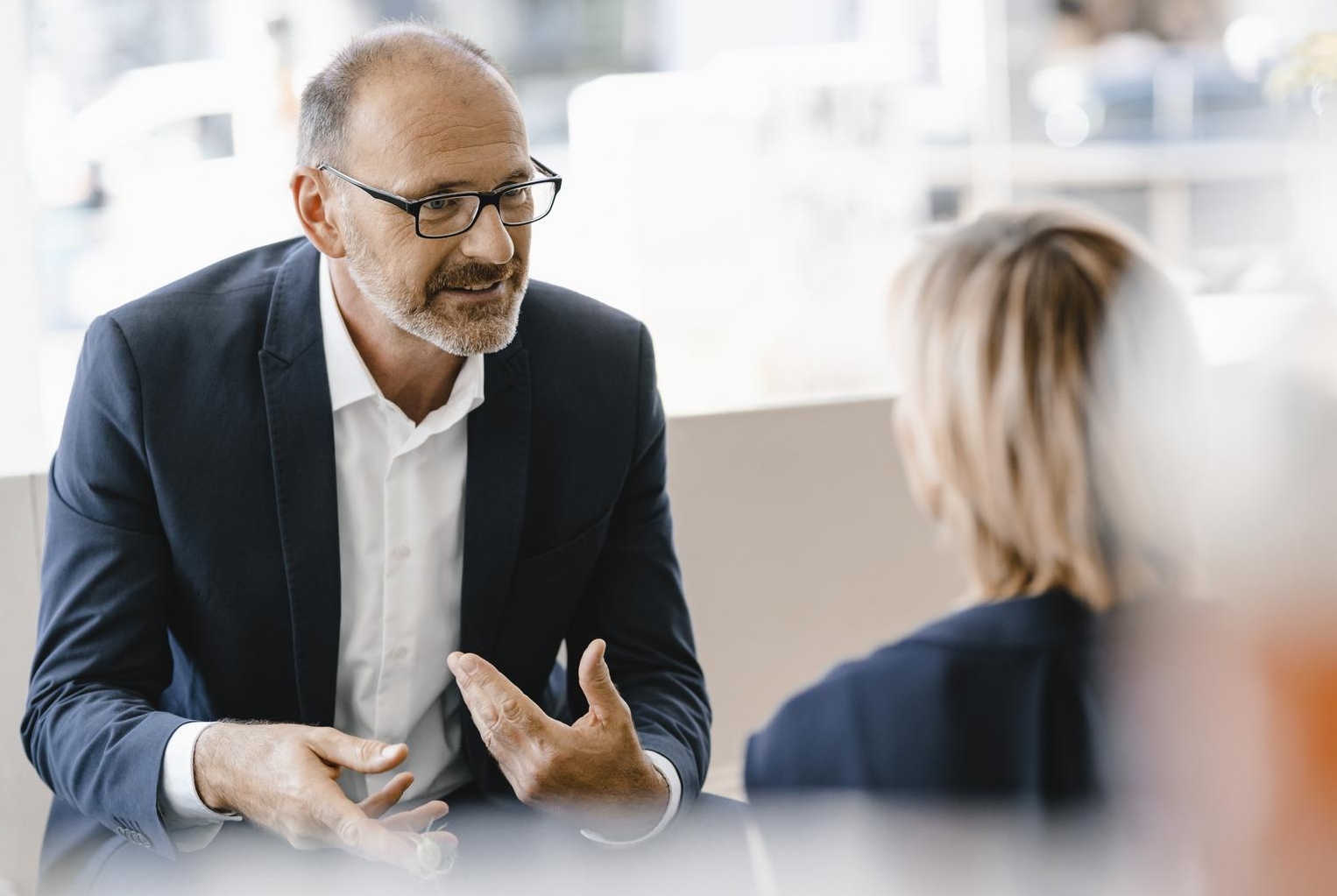 White male talking to white female in office setting