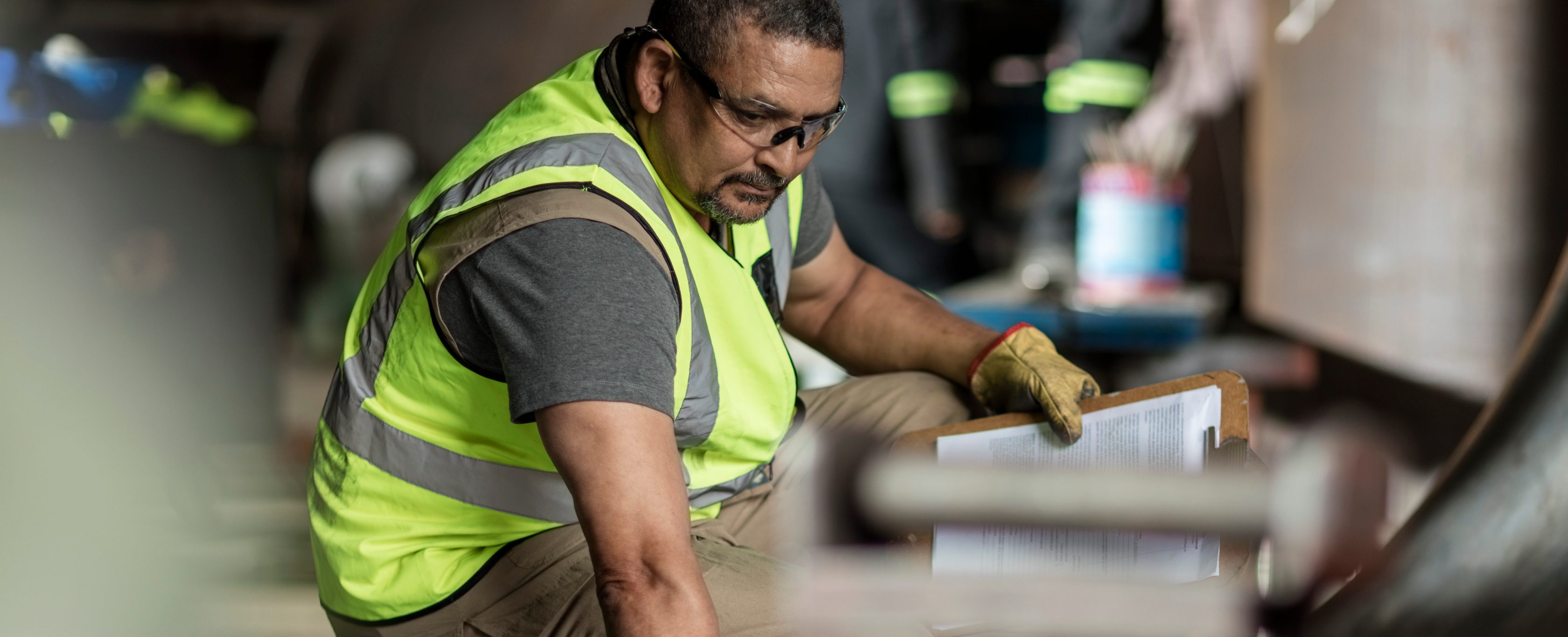 man working in factory with yellow vest