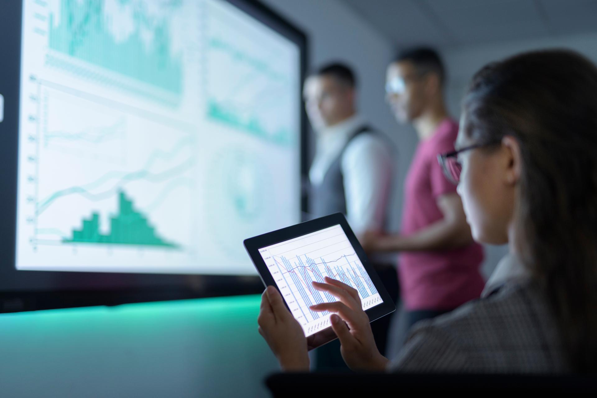 man and woman looking at large screen