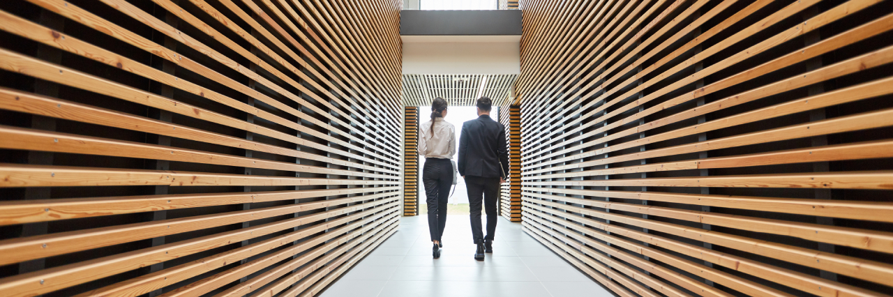 white male and white female walking down hallway