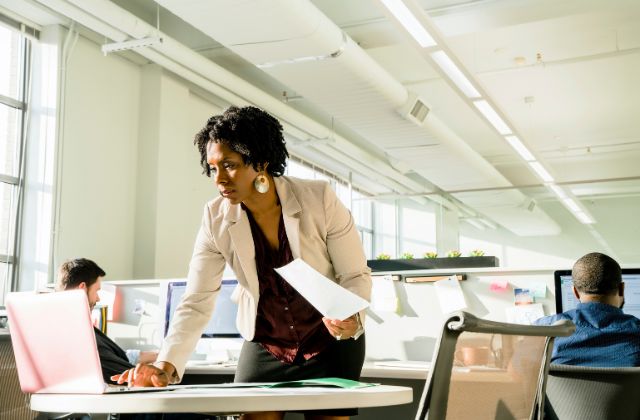 A manager checking data on her laptop in an open space office
