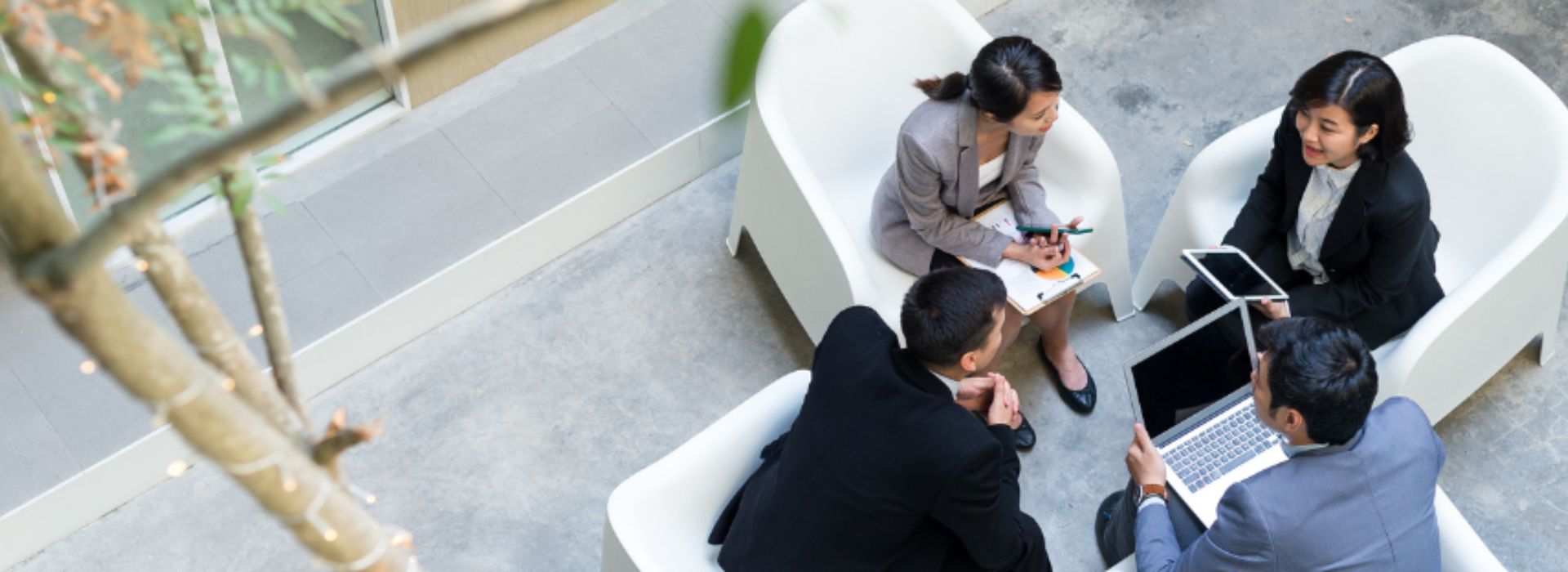 Four business people with computers having a meeting