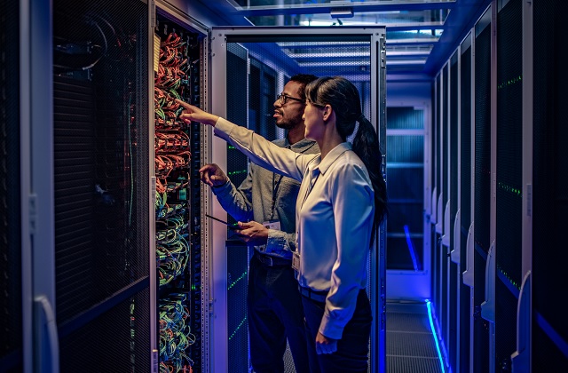 Two IT engineers checking servers in server room