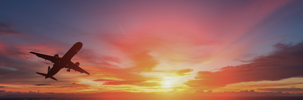 Plane flying with a sunset background