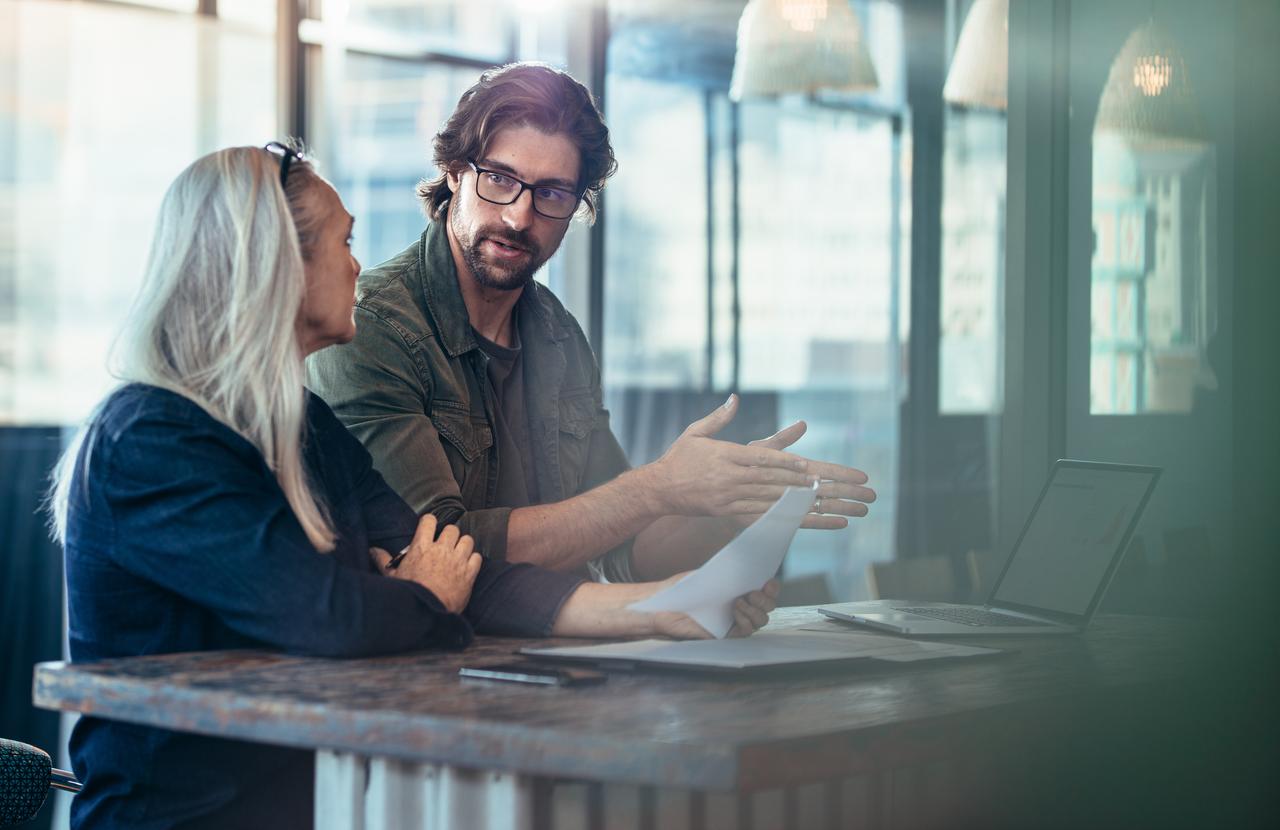 Two people with a computer talking