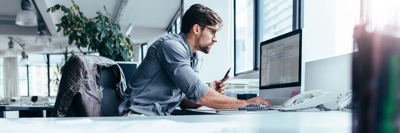 An image of a man working on his computer calculating the gearing ratio