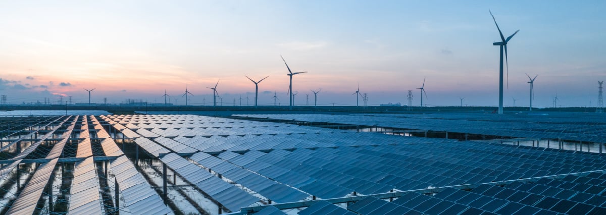 solar power panels and wind turbines on beach