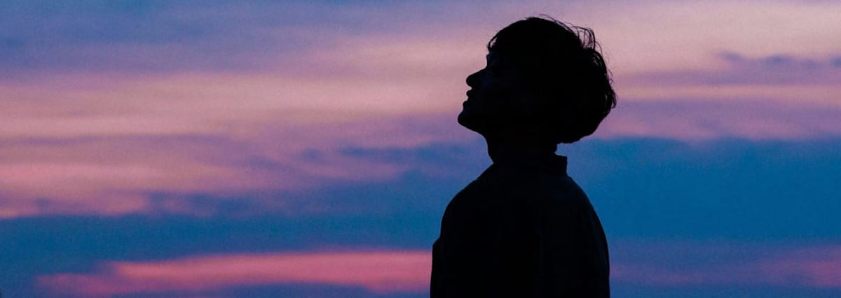 young man looking at the sunrise sky