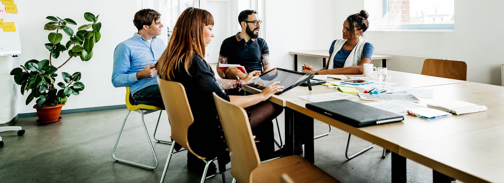 Quattro colleghi in sala riunioni parlano di come ridurre i crediti insoluti