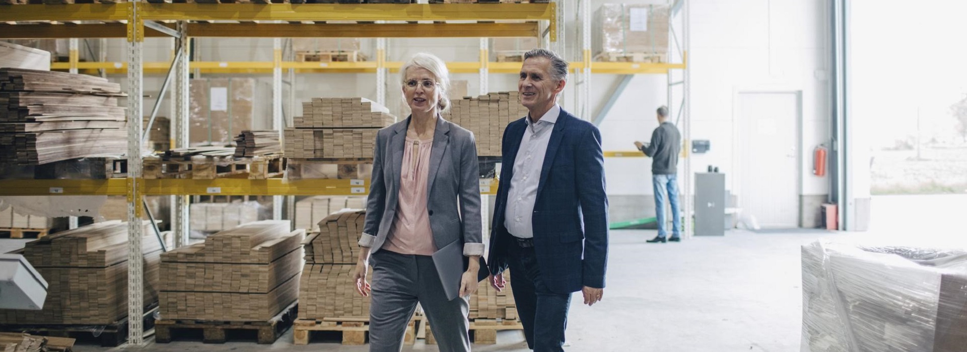 Due imprenditori camminano nel magazzino di un'azienda del settore del legno