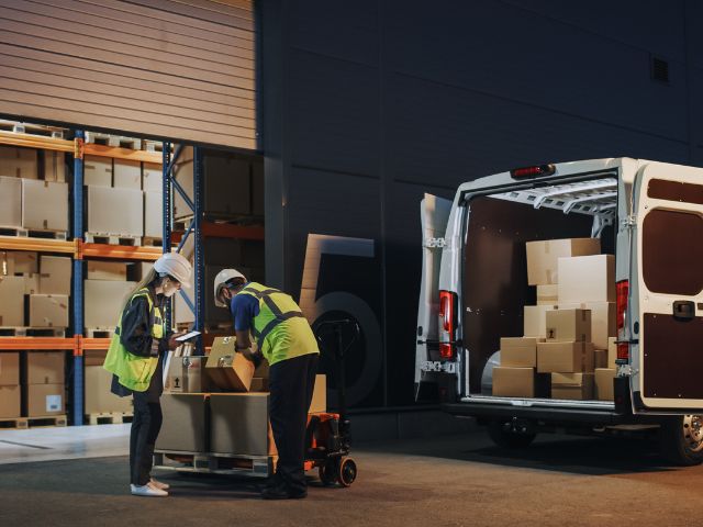 Due operatori logistici riempiono un furgone con merce destinata all'export