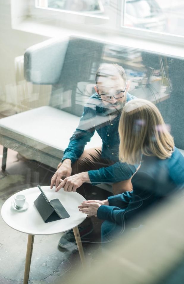 Due persone sedute su un divano parlano di business