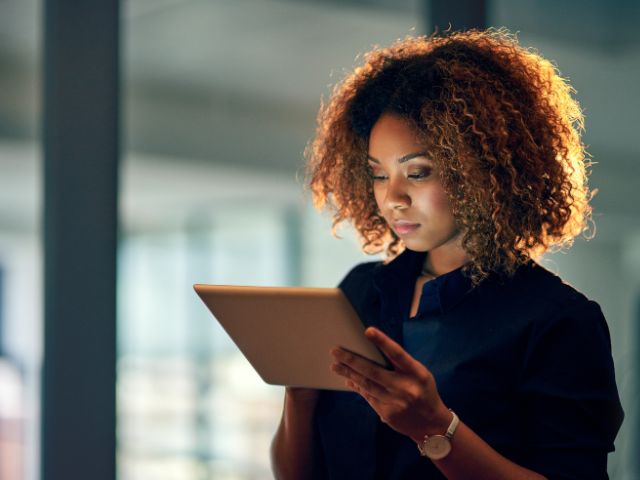 Un'imprenditrice controlla il suo e-commerce usando un tablet