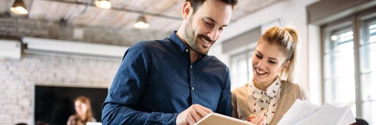 Due colleghi in ufficio che rivedono documenti e lavorano insieme