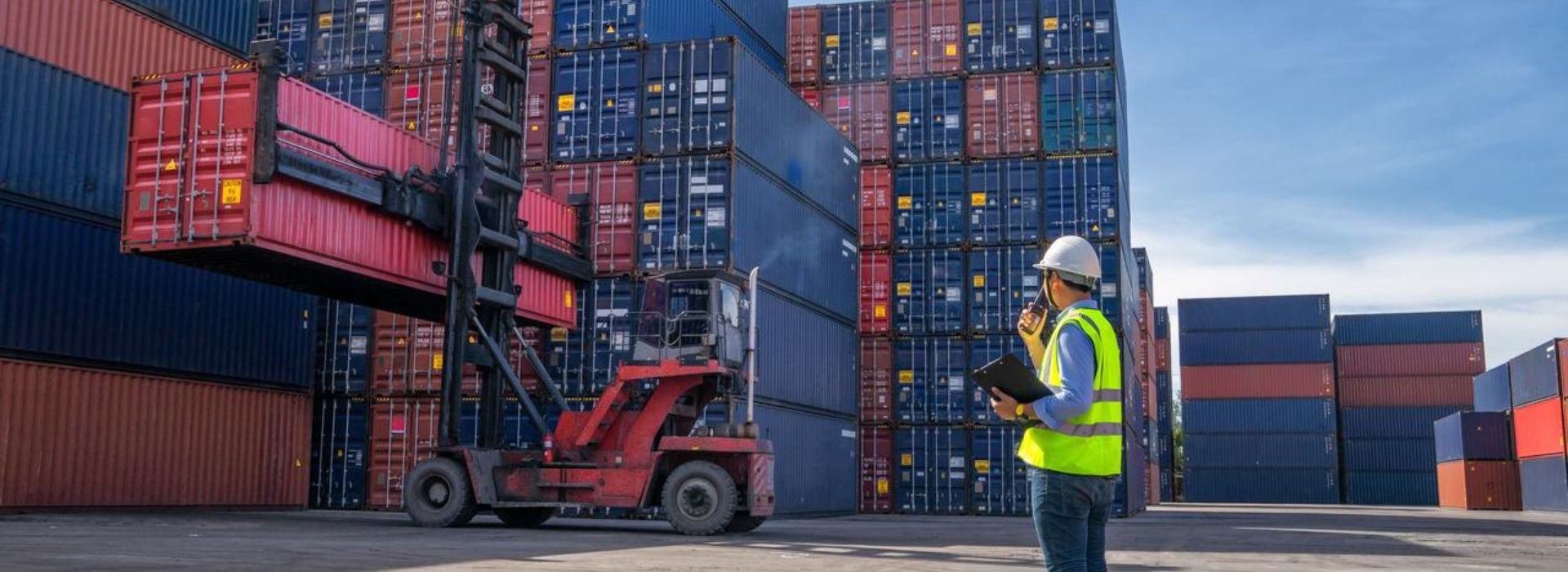 Operaio in un deposito di container che dirige le operazioni logistiche
