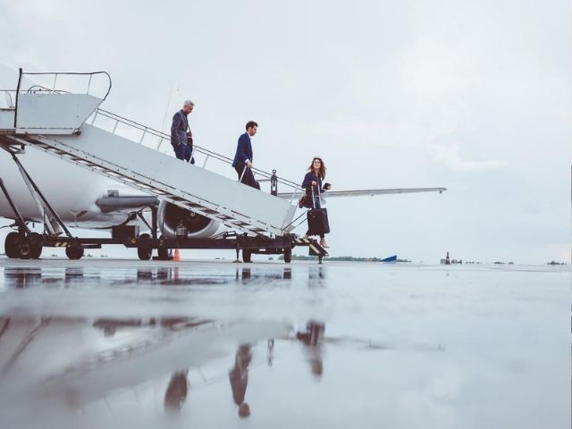 Tre colleghi in trasferta di lavoro scendono da un aereo