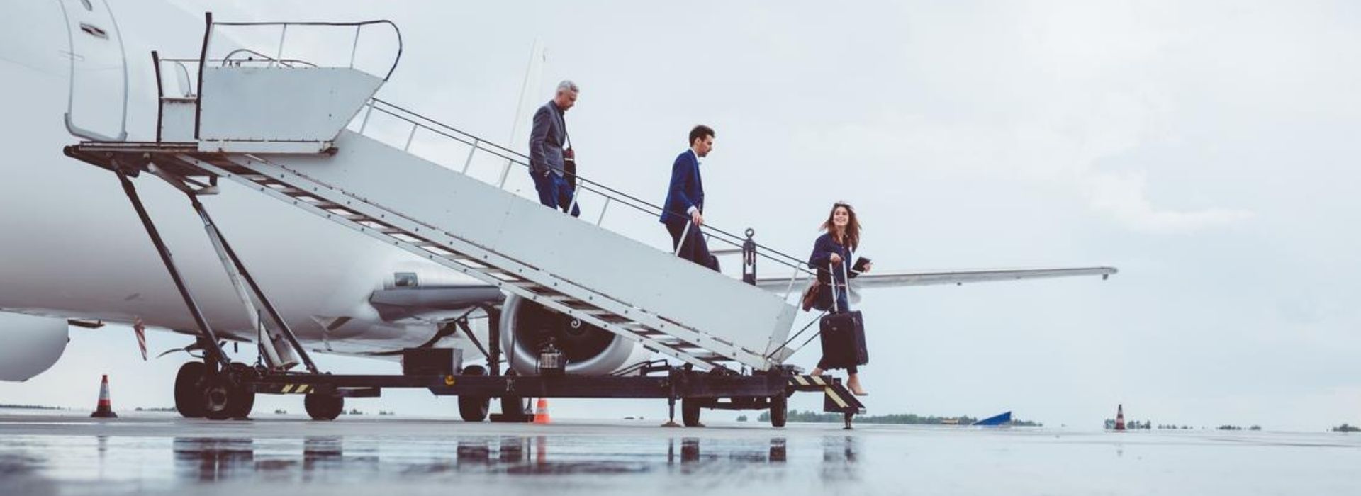 Tre colleghi in trasferta di lavoro scendono da un aereo